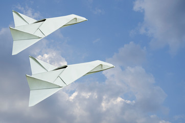 White paper jets on blue sky background