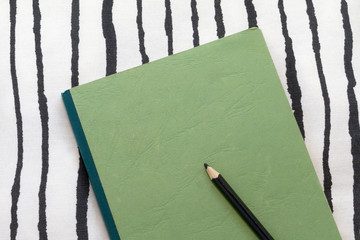 green notebook with black pencil. Diary. plans. Be at home. Tranquility.