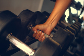 Hand holding a weight in a gym