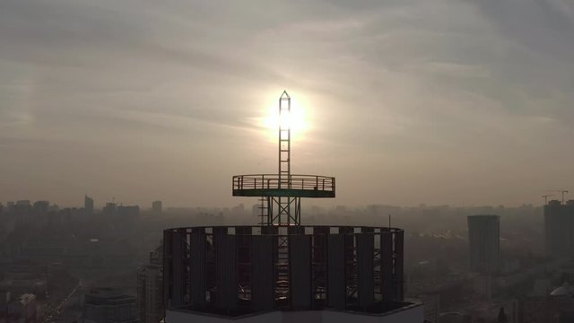 silhouette of a roof spire, lightning rod in a skyscraper. against the backdrop of sunset and evening city center
