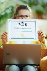 housewife with laptop showing certificate of graduation