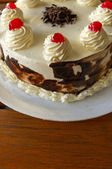 Pastel selva negra en detalle presentado sobre mesa de madera