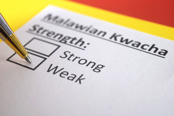 Obraz premium One person is answering question about strength of Malawian Kwacha.