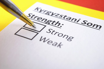 One person is answering question about strength of Kyrgyzstani Som.