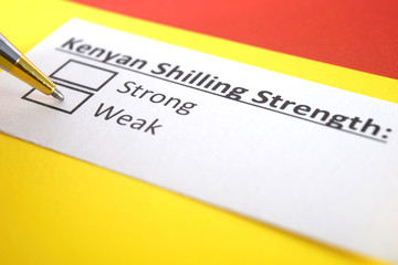Obraz premium One person is answering question about strength of Kenyan Shilling.