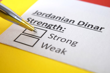 Obraz premium One person is answering question about strength of Jordanian Dinar.