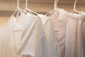 White women's shirts hanging in the wardrobe