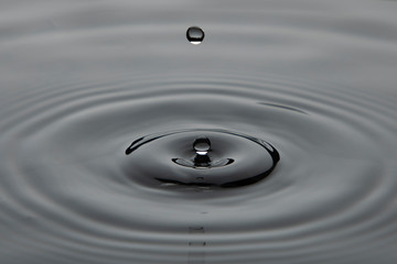 Gota de agua cayendo sobre una superficie liquida formando ondas