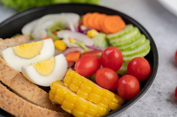 Vegetable salad with bread and boiled eggs in the pan.