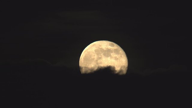 Full moon rising above dark clouds time lapse.mov
