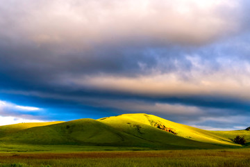 Obraz premium Sunrise with sunlight on Grassy Hill, Clouds