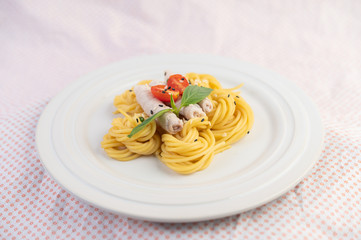 Stir-fried spaghetti and pork, beautifully arranged in a white plate.