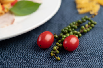 Tomatoes and fresh pepper seeds on patterned fabric.
