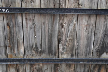 An old fence made in wood. Around two metals supports fixed.