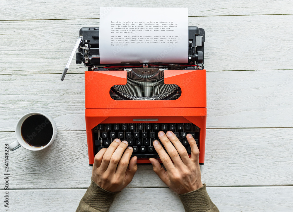 Fototapete aerial view of a man typing on a retro typewriter