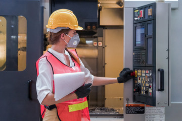 industrial or factory engineering worker and supervisor setting up computerized control panel of...