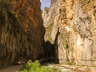 Río entre montañas con carretera en ruta