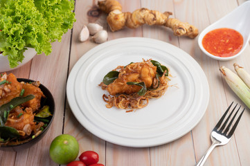 Herb fried chicken on a white plate on a wooden floor.
