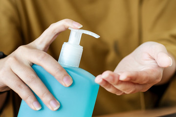 Woman cleaning hands with a hand sanitizer gel to prevent coronavirus contamination