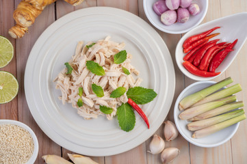 The chicken that is bordered is cooked and placed in a white plate along with mint leaves.