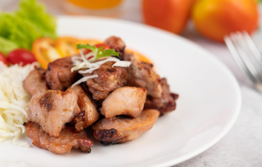 Fototapeta premium Grilled pork cutlet with tomatoes and salad, arranged in a white dish.