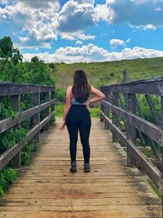 young woman walking on the bridge amazed by the beauty of nature 