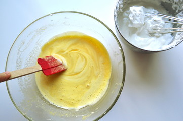 Recipe sequence - mini fruit sponge cakes - baking preparation.  Mixing eggs, yolks, flour and fruit into a liquid batter