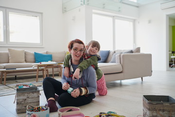 Obraz premium Mother and little girl daughter playing with jewelry at home