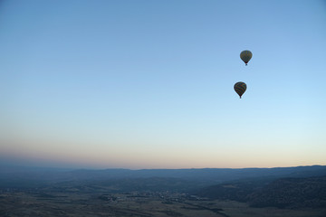 Panoramic view of mountain landscape with hot air balloon floating in the sky