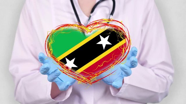 close-up. Doctor in medical white coat, blue gloves holds in hands drawn pulsating heart with Saint Kitts and Nevis flag. Concept of doctors struggling against global epidemic, coronavirus.