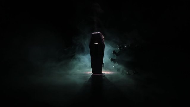 Creative artwork. Miniature wooden coffin on a table with dark background. Selective focus