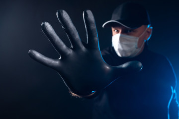 The man with the mask stretched forth his hand in black rubber glove. A hand in a black rubber...