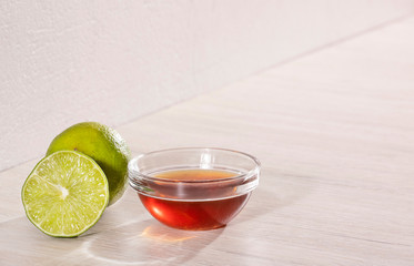 Honey in a glass bowl and lemon on the wooden table