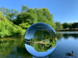 Crystal lens refractory ball with an inverted image of landscape in the park
