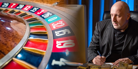 The concept of winning in a casino. The man carefully looks at the roulette wheel and develops a...