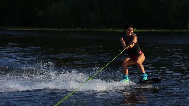 Young sexy female model ridding on wakeboard 