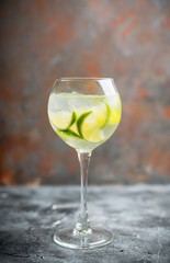 Rum based cocktail with lime in wine glass (variation of cuba libre) on the rustic background. Selective focus. Shallow depth of field.
