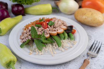 Stir-fried noodles with minced pork, edamame, tomatoes and mushrooms in a white plate.