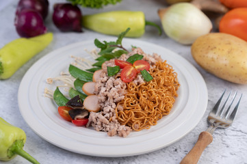 Stir-fried noodles with minced pork, edamame, tomatoes and mushrooms in a white plate.