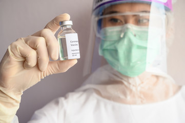 Fototapeta premium Scientist doctor holding a sample test bottle of Covid-19 vaccine. Vaccination is one of the most effective ways to prevent diseases and helps the body’s immune system from virus.