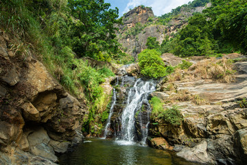 Fototapeta na wymiar Beautiful view of Ravana Falls a popular sightseeing attraction in Ella a mountain town in the central highland of Sri Lanka. This waterfall measures approximately 25 m (82 ft) in height.