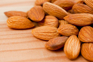 Almonds nuts shot large on a wooden background. Background for healthy eating and vegetarianism.