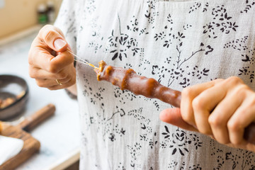 Woman hold Churchkhela - traditional Georgian sweet candy dessert stick with grape juice and walnuts