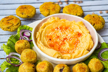 Chickpea hummus to eat with falafel balls and green lettuce leaves. Vegan food.