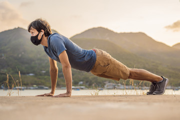 Young man performing some workouts in the park during coronavirus quarantine