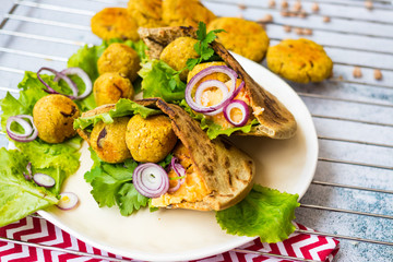 Baked chickpea falafel to eat with hummus, salad leaves and pita bread. Vegan healthy food.