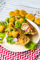 Baked chickpea falafel to eat with hummus, salad leaves and pita bread. Vegan healthy food.