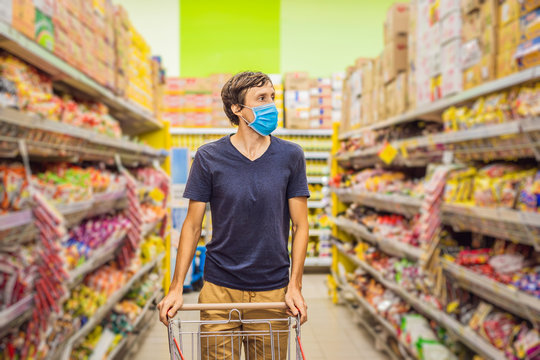 Alarmed Man Wears Medical Mask Against Coronavirus While Grocery Shopping In Supermarket Or Store- Health, Safety And Pandemic Concept - Young Woman Wearing Protective Mask And Stockpiling Food