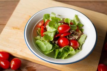 Red ripe tomato and mixed green leaf, cook a salad for dinner or breakfast for dieting and healthy eating.