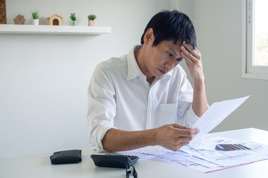 Image Of A Business Man With Financial Concerns. Think Hard About Paying Off Credit Card Debt, House Rent, And Family Expenses. Financial Problem Concept